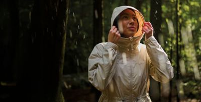 A woman in spring hiking gear in a mossy wood.
