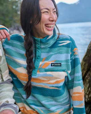 A woman in cozy fleece by a lake.