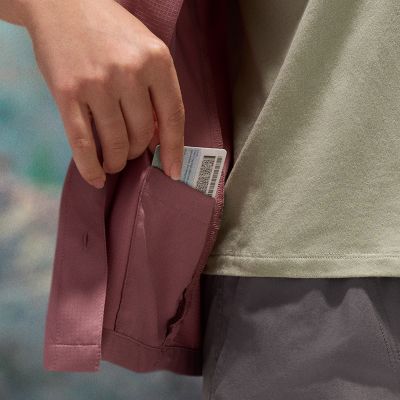 Close-up of a model slipping a driver's license into the interior pocket.