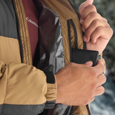Model slipping a wallet into a zippered interior pocket.