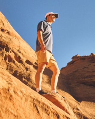 A man in a polo and shorts in the desert.