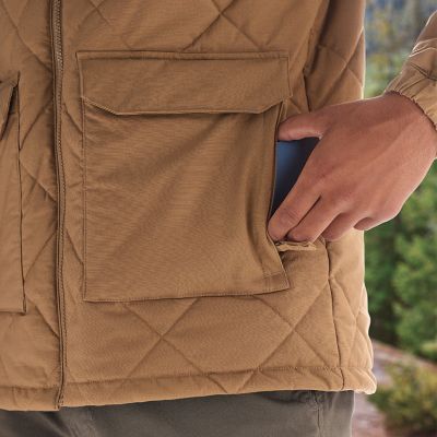 Close-up of model slipping a phone into the zippered hand pocket.