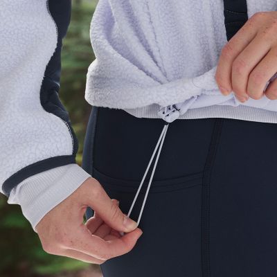 Close-up of a model pulling the drawcord on the adjustable hem.