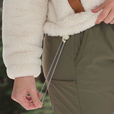 A younger woman in a coral pink fleece and blue pants.