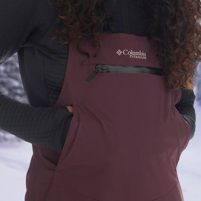 Close-up of model wearing a bib with a front zippered pocket and hand pockets.
