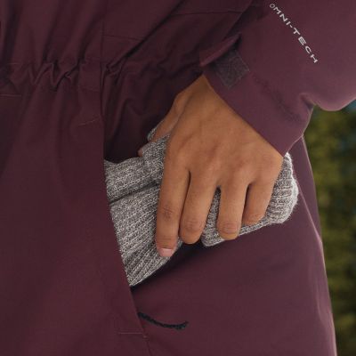 Model placing a beanie into the zippered hand pocket.