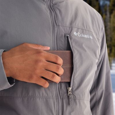 Close-up of a model putting their wallet in the zipping chest pocket