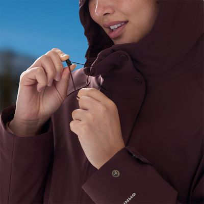 Model unzipping the bottom legs off of the tan convertible pants.