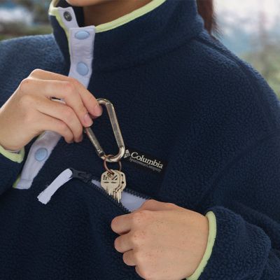 Model placing keys into the chest zip pocket.