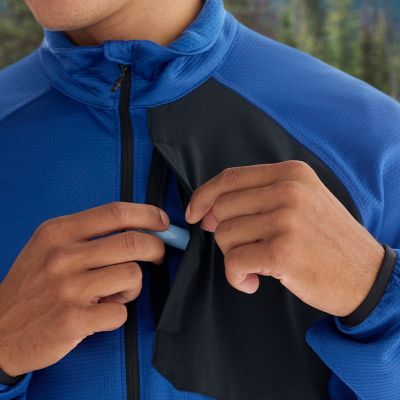 Close up of a model putting chapstick in the zipping chest pocket