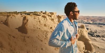 A man hiking in the desert wearing sun blocking gear.