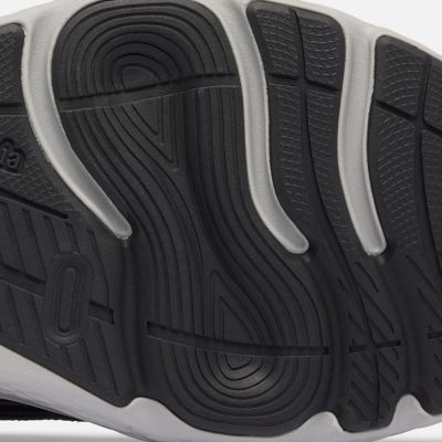 Close-up of a model revealing the bottom traction of their running shoe.