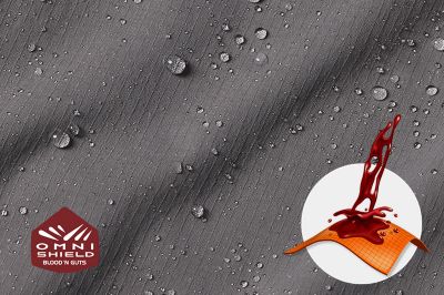 Close up of fabric with the Omni Shield blood n guts logo in the bottom left and a graphic showing how moisture beads on the fabric's surface.