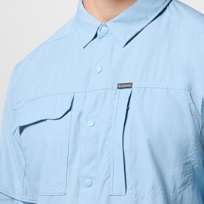 Close-up of a woman buttoning a Silver Ridge shirt. 