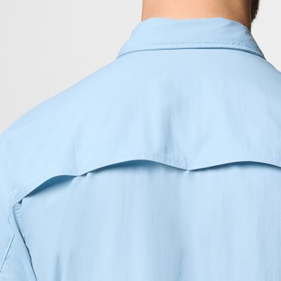 Close-up of a woman buttoning a Silver Ridge shirt. 