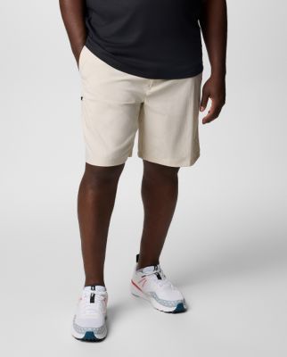 Waist-down image of a man wearing black shorts and white sneakers.
