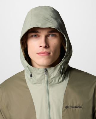 ⁨Woman wearing a tan rain jacket.