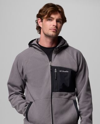 A man wearing a grey fleece zip-up jacket.