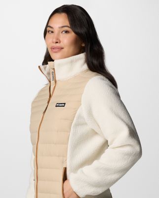 A woman wearing a cream-colored insulated jacket.
