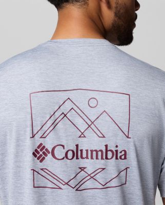 Man wearing a white t-shirt with a mountain graphic.