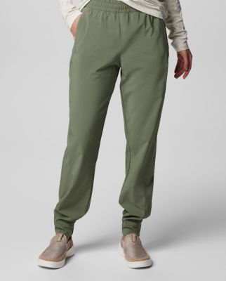 Waist-down image of a woman wearing green shorts and sneakers.