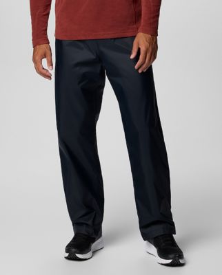 Waist-down image of a man wearing navy pants and sneakers.
