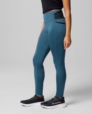 A woman wearing blue leggings with sneakers.