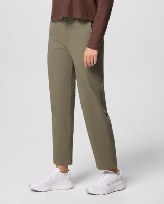 A woman wearing light green pants with white snow boots.