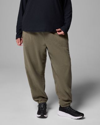 Waist-down image of a woman wearing green shorts and sandals.