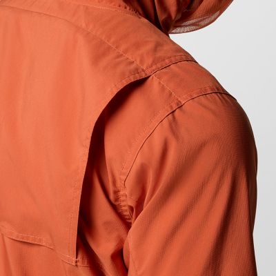 Close-up of a woman buttoning a Silver Ridge shirt. 
