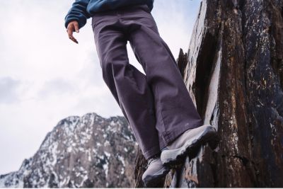 A woman scaling a cliff in the ROC pants.