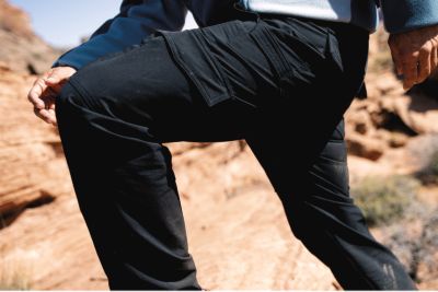 A man bending in the pants showing the stretch.