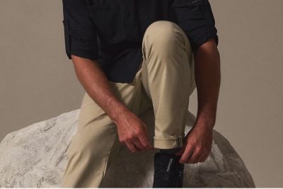 A man bending in the pants showing the stretch.