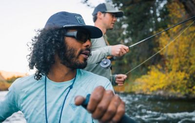 A man fly fishes as another man rows the raft into position. 