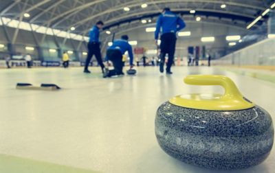Curlers in an indoor rink work together for the next point. 