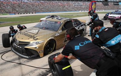 Bubba’s highly efficient Pit Crew, wearing Columbia Sportswear logos on their shirts, change the tires on the Columbia-wrapped car. 

 