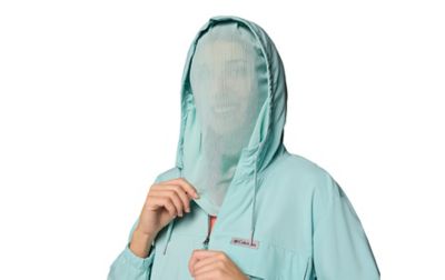 A woman wears a long-sleeve jacket featuring sheer netting that extends from the hood to her neck.