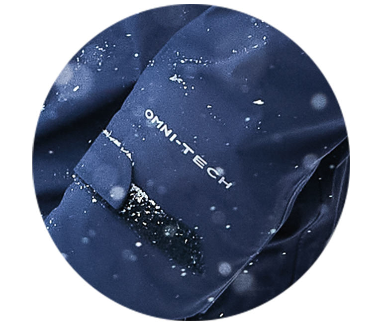 A blue jacket sleeve with Omni-Tech in the snow.