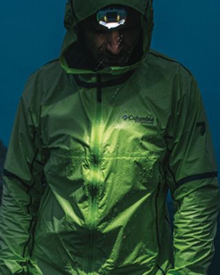 A person in a jacket at night with a headlamp.
