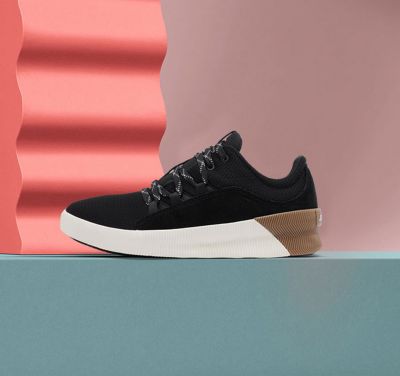 An Out 'N About waterproof sneaker on a pink background
