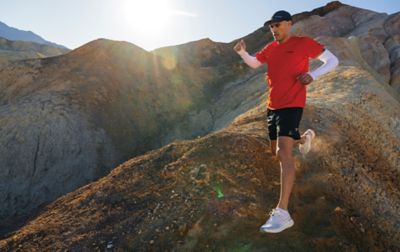 Un homme portant un équipement Columbia Sportswear dévalant une colline rocheuse.