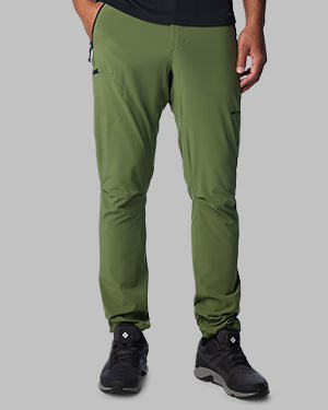 A man from the waist down slightly slim fitting in green pants and sneakers.