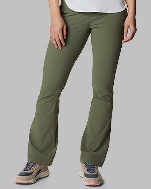 A woman from the waist down in slightly slim fitting green pants and sneakers.