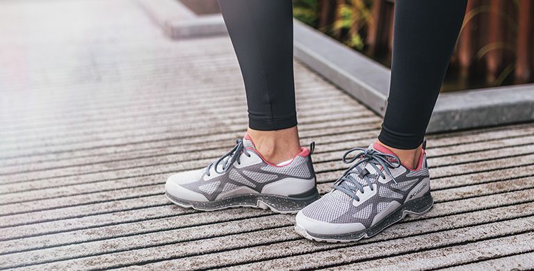 Close-up of a person wearing Vitesse sneakers outdoors. 