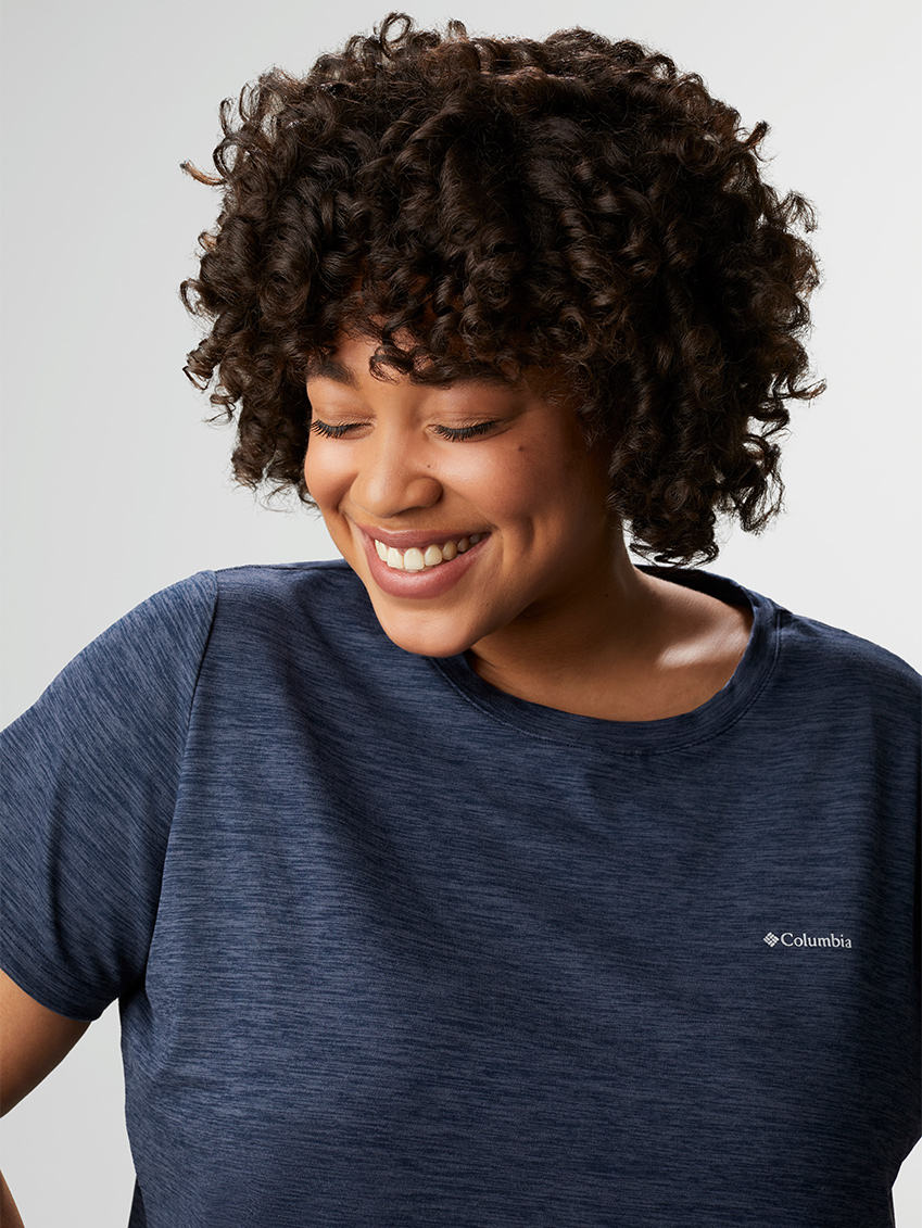 Close-up of a smiling woman in a navy blue hiking t-shirt.