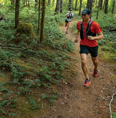 Un hombre runner de trail. y pies de atleta con calzado deportivo para  correr en el bosque