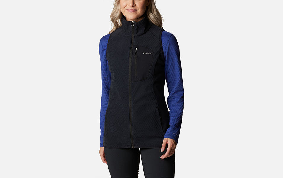 A product image of a woman wearing Columbia Sportswear’s Outdoor Tracks Vest against a white background. 
