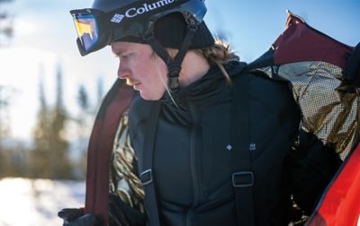 A person removing a Columbia Omni-Heat Infinity Jacket showing off the gold lining. 