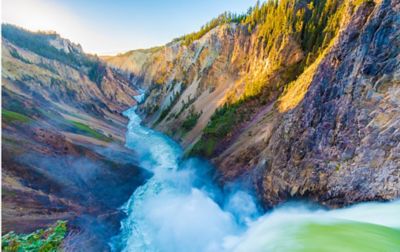 Rushing water from the perspective of a massive waterfall flowing through the Grand Canyon of Yellowstone National Park. 