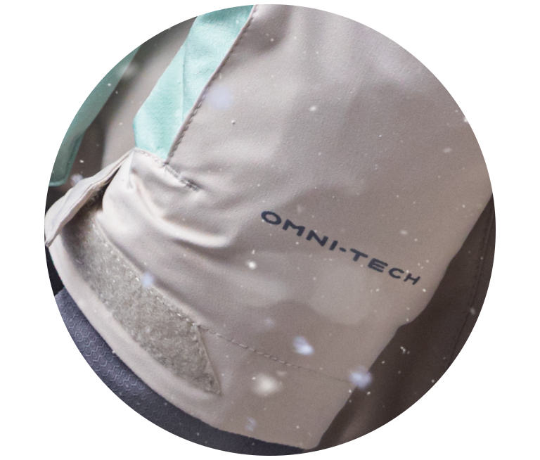 A blue jacket sleeve with Omni-Tech in the snow.